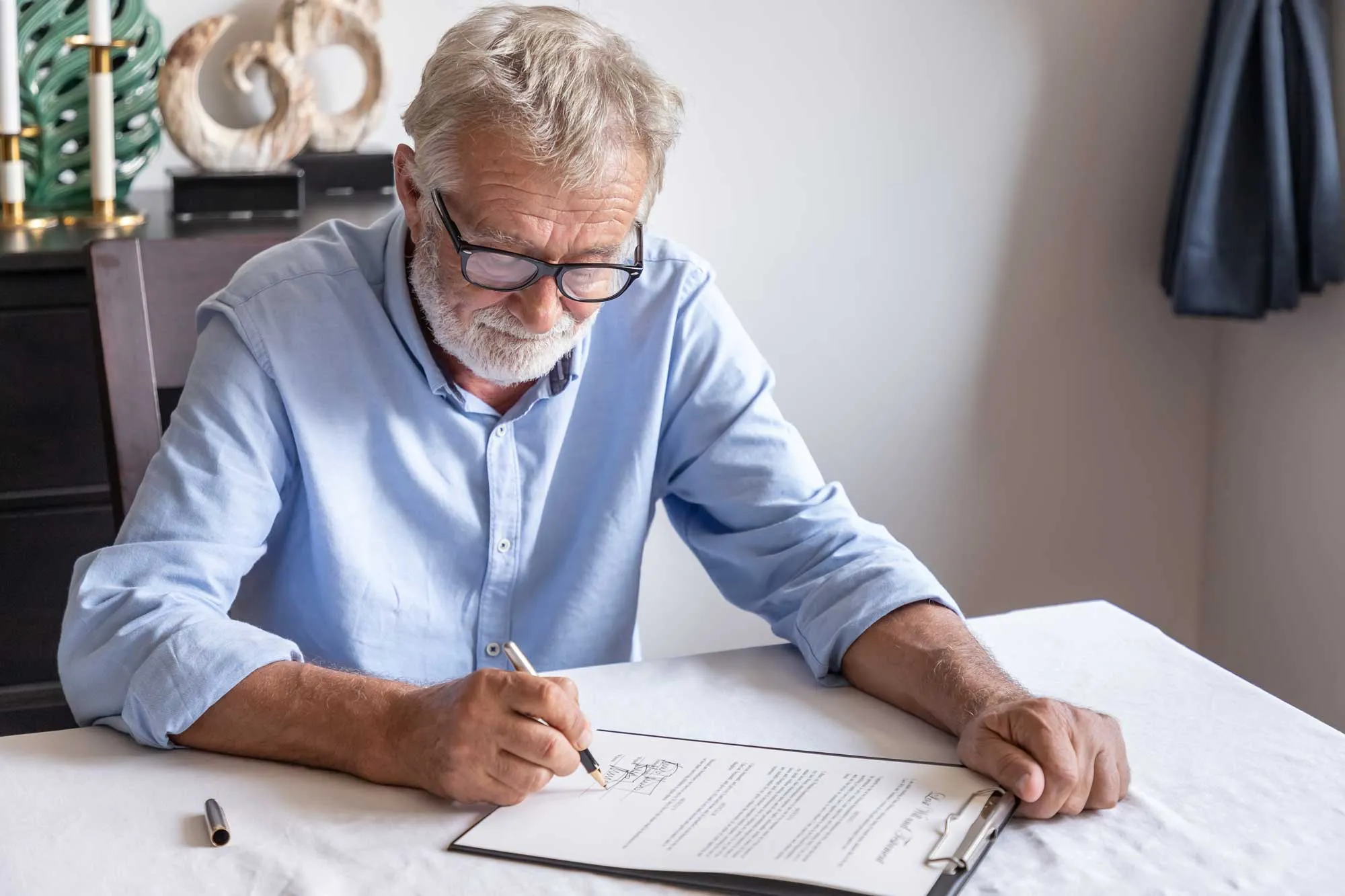 An elderly man focused on writing